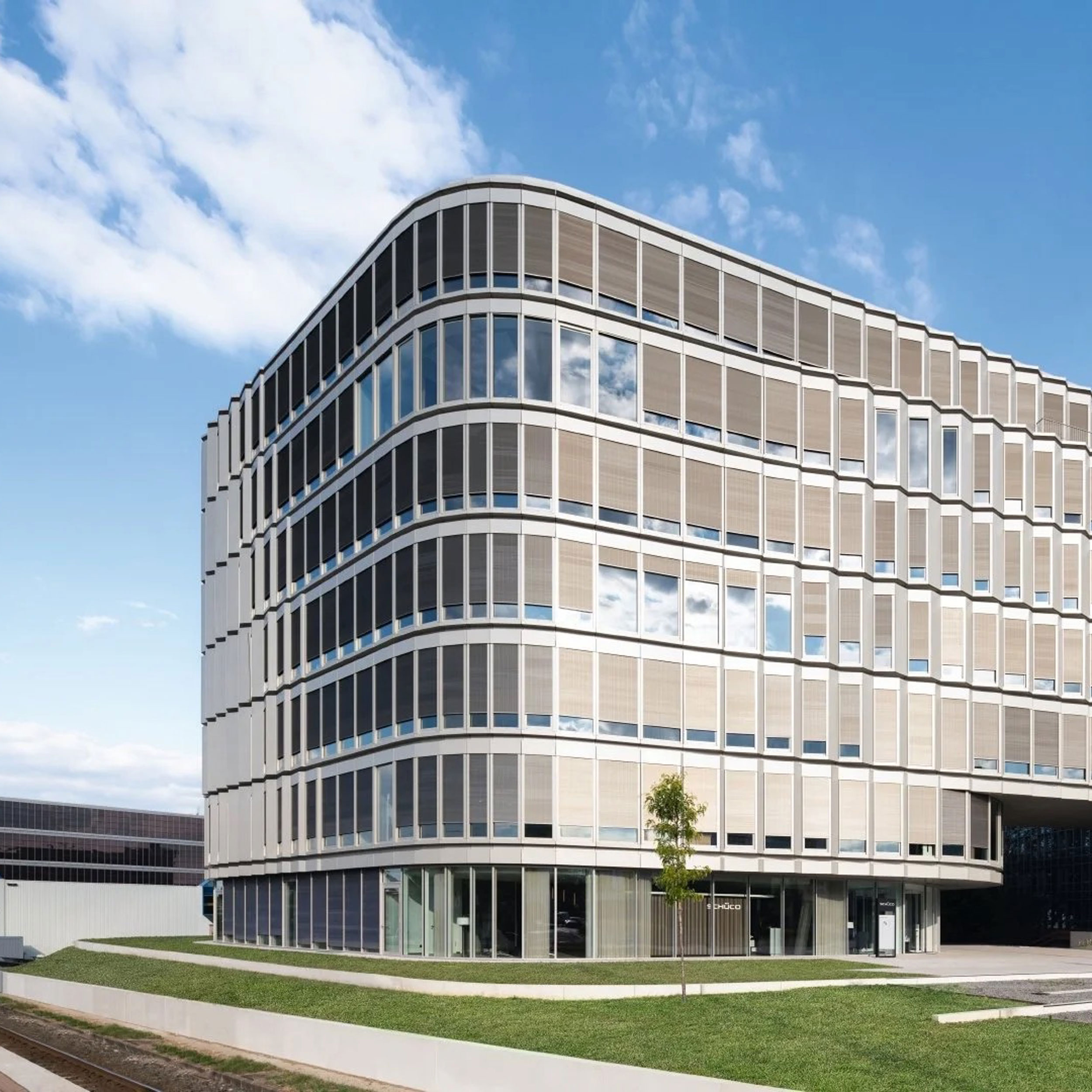 Die moderne, geschwungene Fassade des Schüco Headquarters, die die Expertise und den technologischen Vorsprung für energetische Fassadensanierung demonstriert